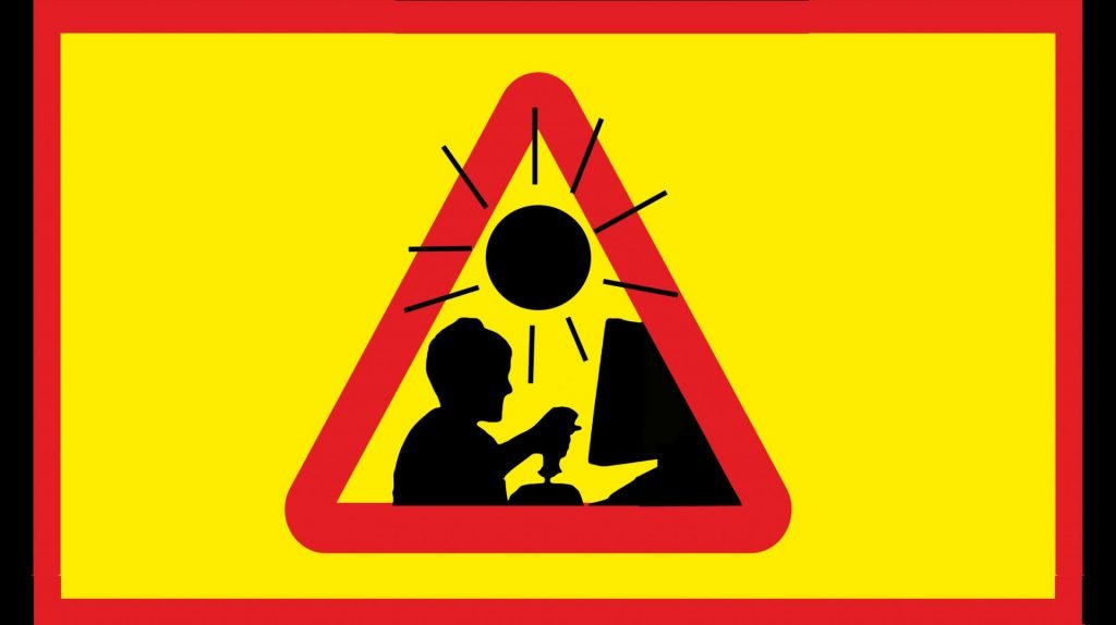 Bilden föreställer en triangulär, rödgul varningsskylt mot en gul bakgrund. På skylten ser man silhuetten av ett barn som spelar datorspel framför en skärm. Ovanför barnet är en svart, stiliserad sol.